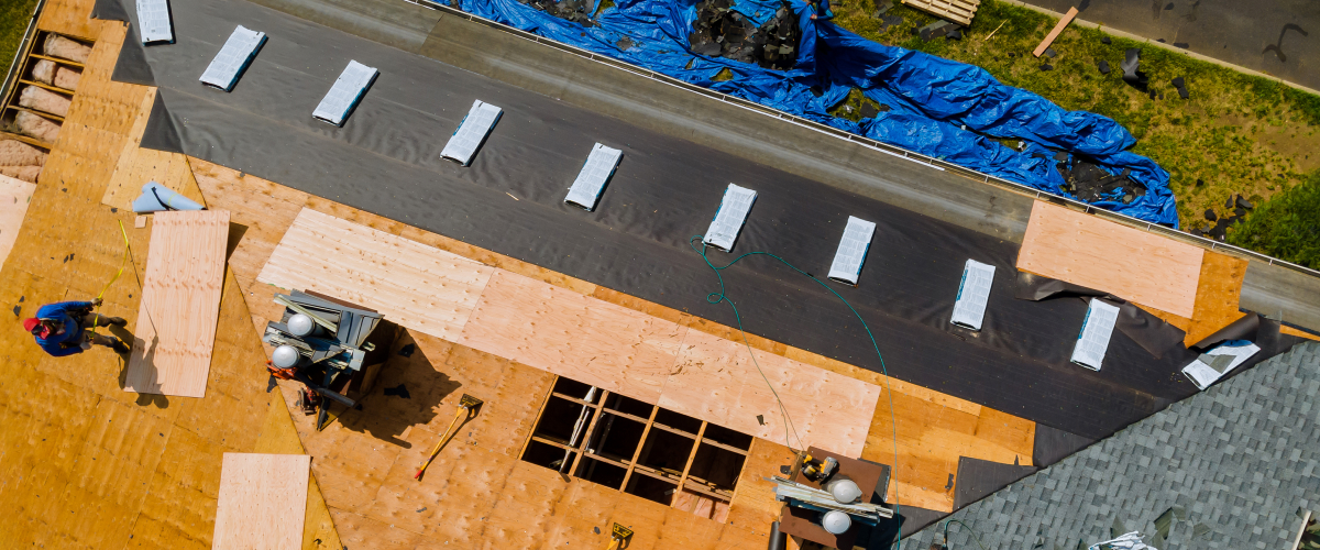 Roofer working on top of a unfinished roof.